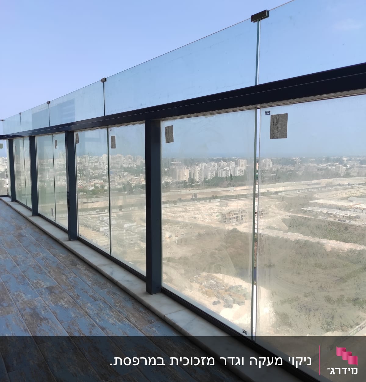 מעקה זכוכית מלוכלך במרפסת עם סימני לכלוך